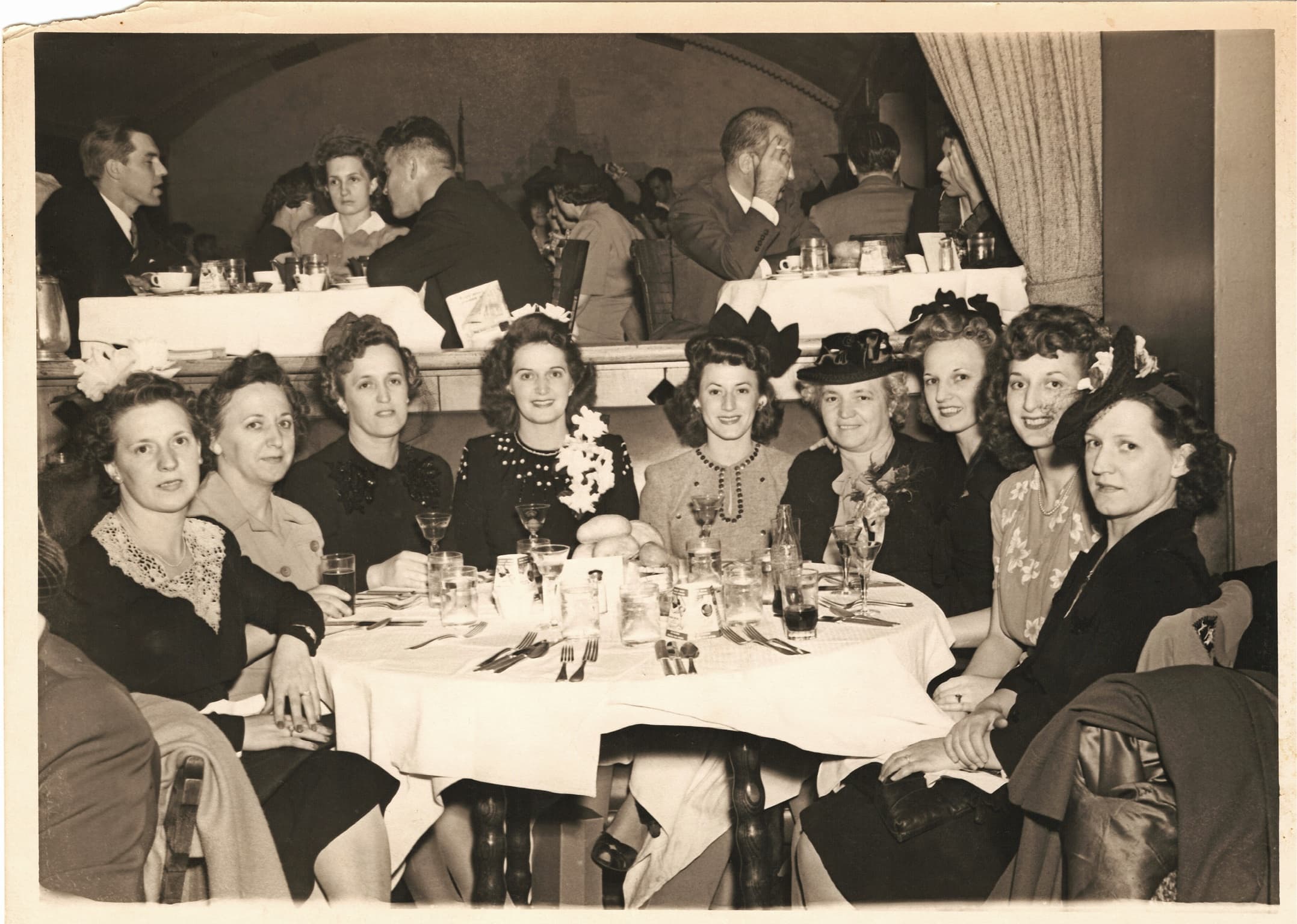 Helen with her sisters and her mother seated at a restaurant table in 1944